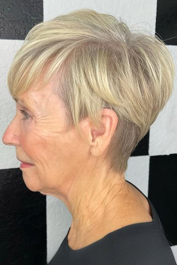 Choppy Blonde Pixie With Bangs Haircut, side view.