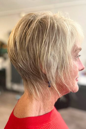 Tapered Blonde Pixie With Textured Long Layers Haircut, side view.