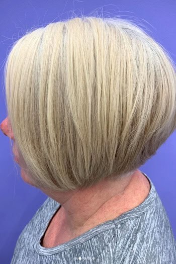Rounded Blonde Bob Hairstyle on a woman with thick hair in her 50s, side view.