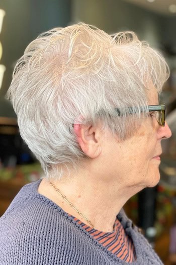 Layered White Pixie With Soft Waves Haircut, side view.