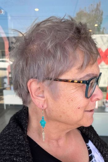 Wispy Gray Pixie With Choppy Crown Haircut, side view.