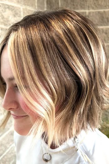 Short Dimensional Blonde Bob With Highlights Hairstyle, side view.