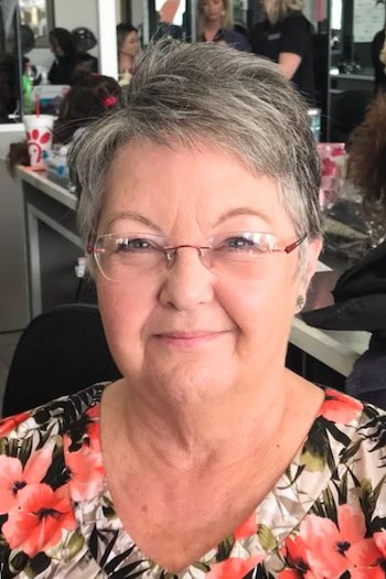 Short Gray Pixie With Texture Hairstyle on a woman in her 60s wearing glasses.