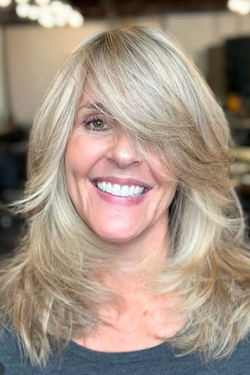 Feathered Medium-Length Layers With Long Side-Swept Bangs Haircut