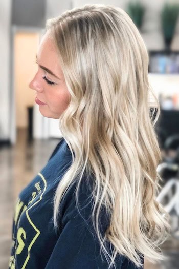 Silky Platinum Blonde Beach Waves Hairstyle, side view.