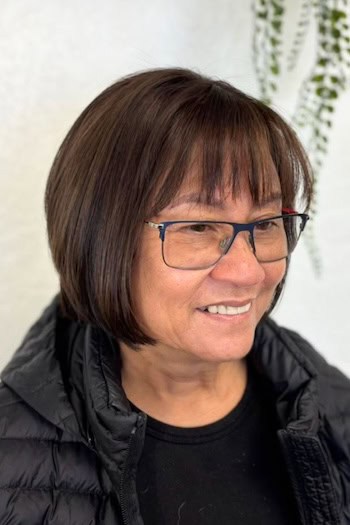 Straight Bob With Piecey Bangs Hairstyle on a woman in her 60s wearing glasses.