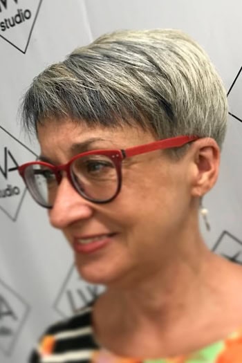 Silver Pixie With Red Glasses Hairstyle on a woman in her 60s.