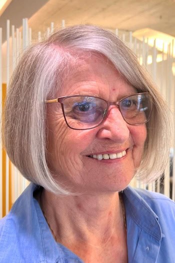 Silver Bob With Side Part Hairstyle on a woman in her 60s wearing glasses.