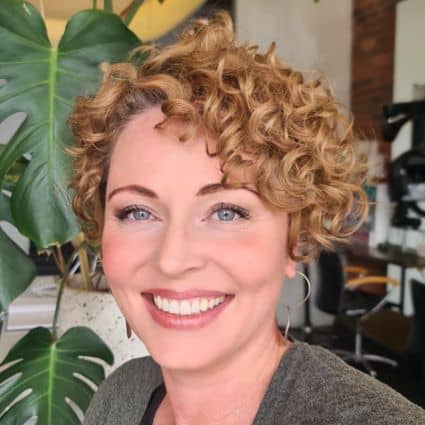 Curly pixie haircut for thick hair with defined ringlets.