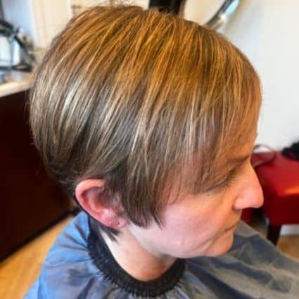Blended Brunette Pixie with Bangs and Long Sides Haircut, side view.