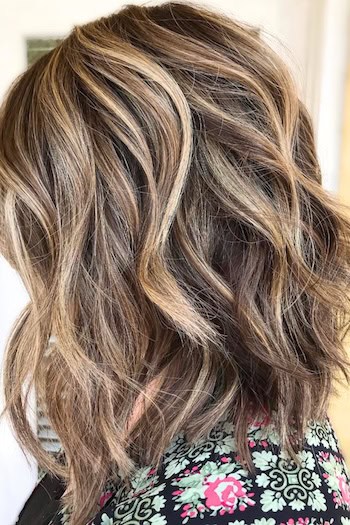 Wavy Long Bob with Blonde Highlights Hairstyle, side view.