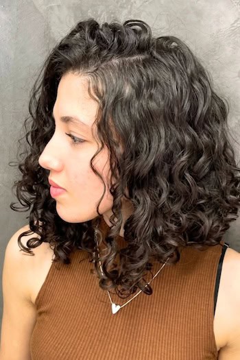 Curly Dark Long Bob Hairstyle, side view.