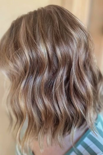 Modern Wavy Long Bob with Highlights Hairstyle, side view.